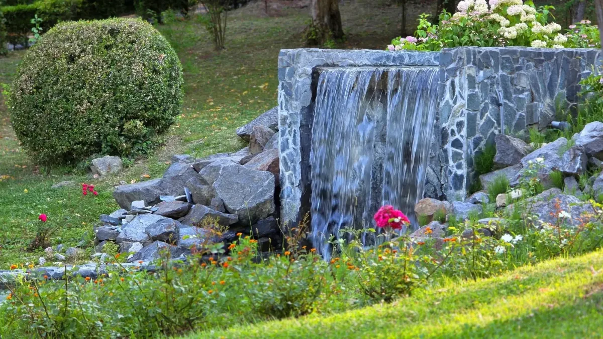 Cascadă decorativă, flori și vegetație în parcul balnear Băile Govora.
