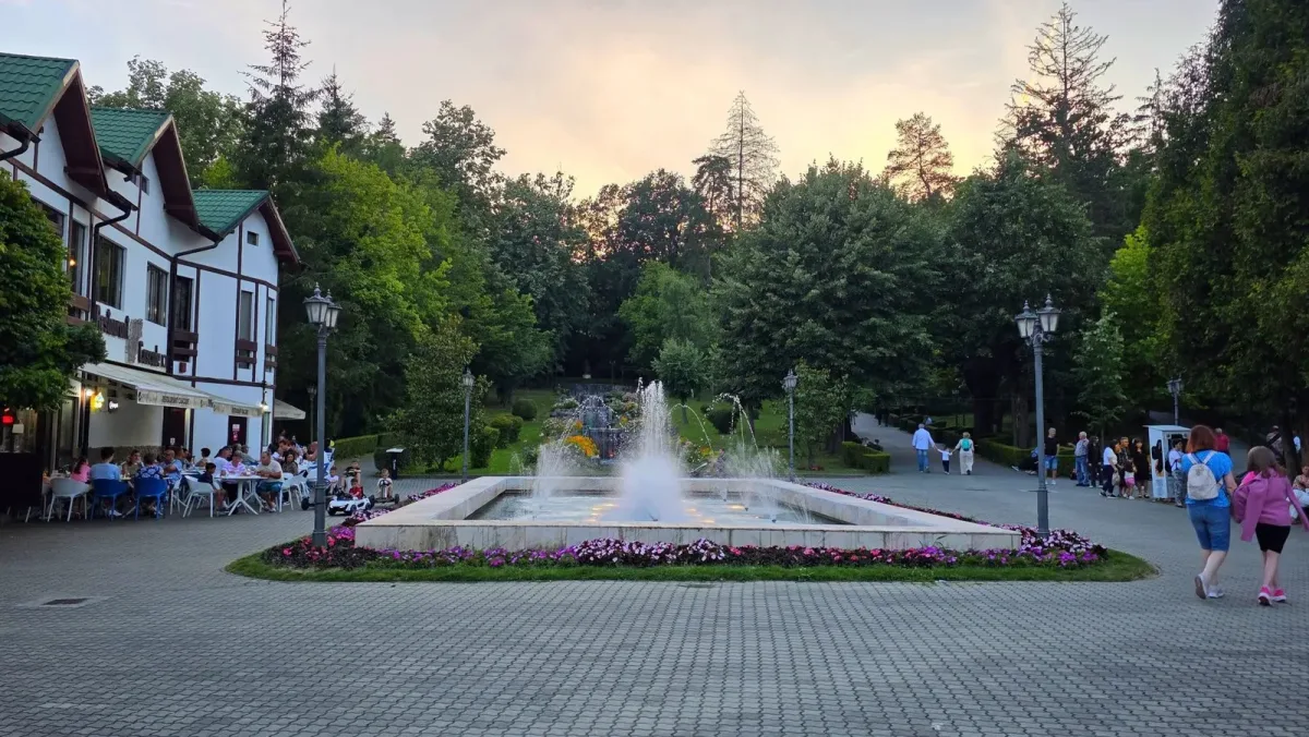 Piațeta și fântâna centrală din Băile Govora la începutul serii.
