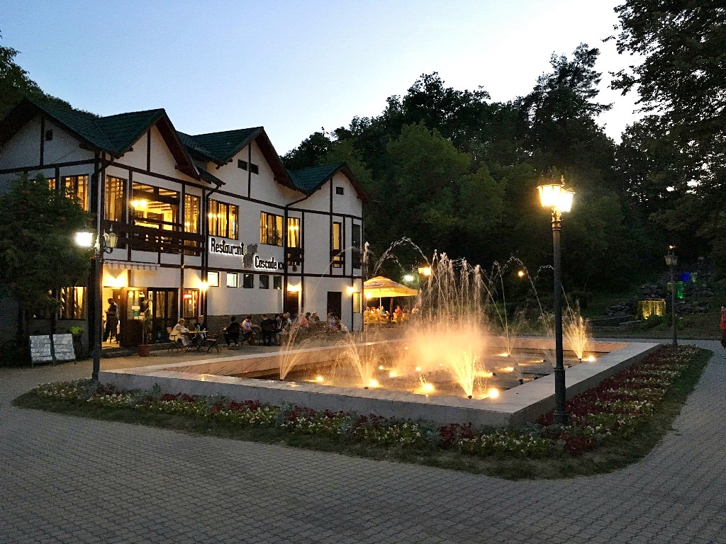 Perspectivă simetrică asupra scărilor, rondurilor și aleii din parcul balnear.